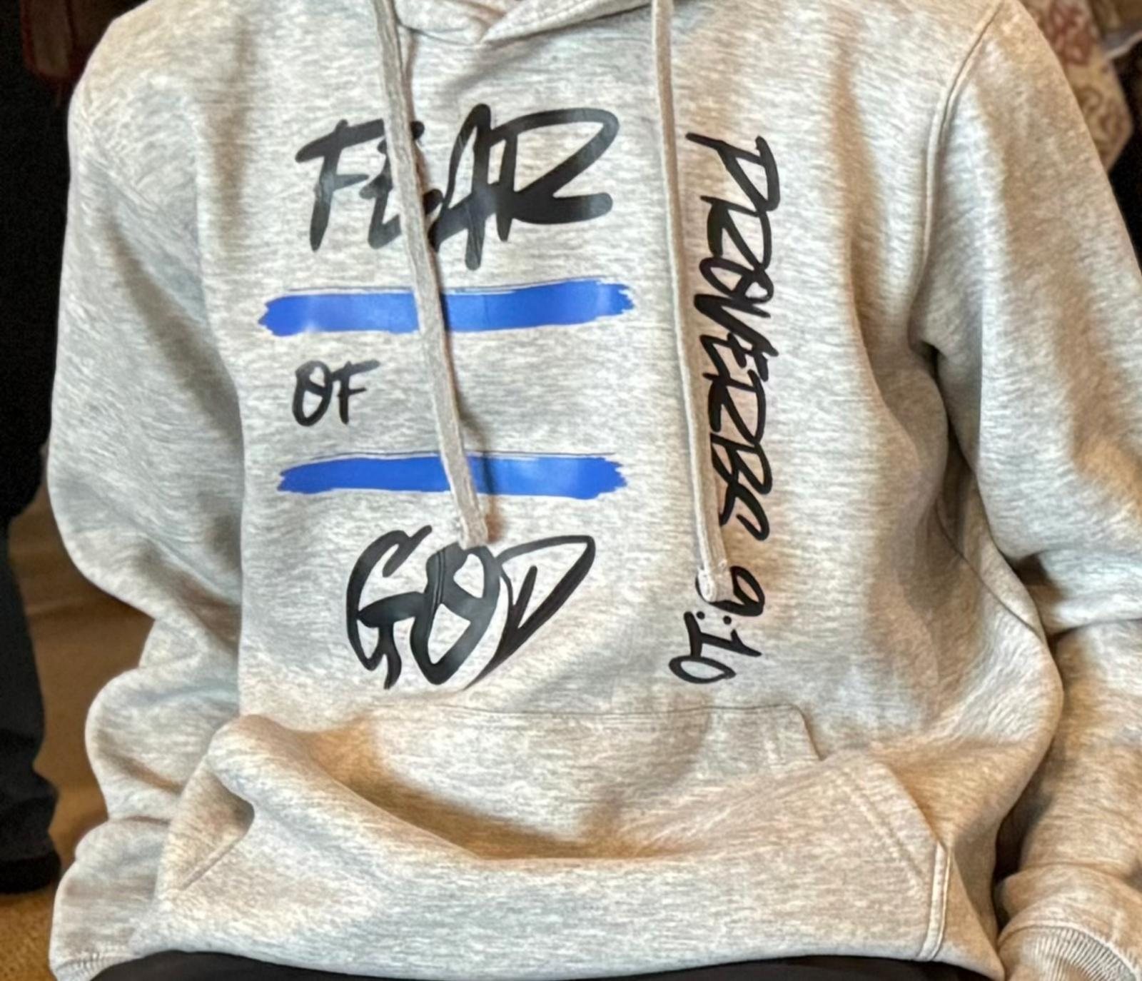 Cream custom hoodie with a hand-drawn "Fear of God" graffiti-style print, laid flat